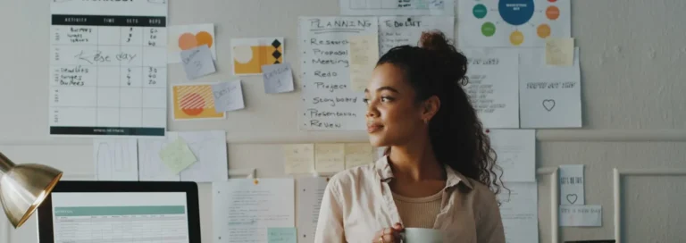 Shot of a young businesswoman standing and looking contemplative while holding a cup of coffee in her office