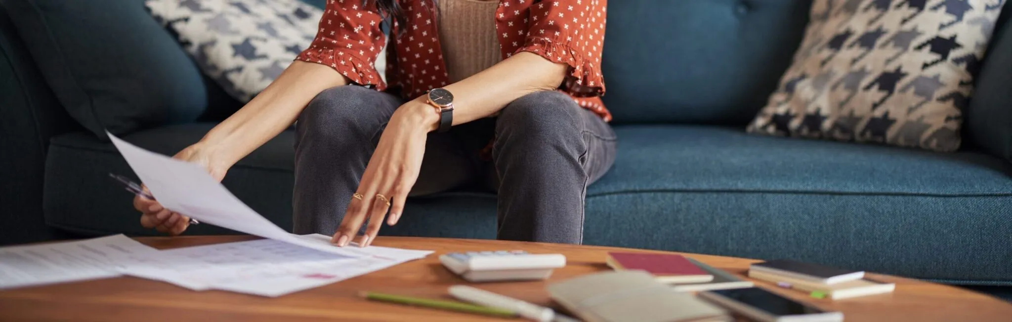 Focused young woman reviewing financial documents at home