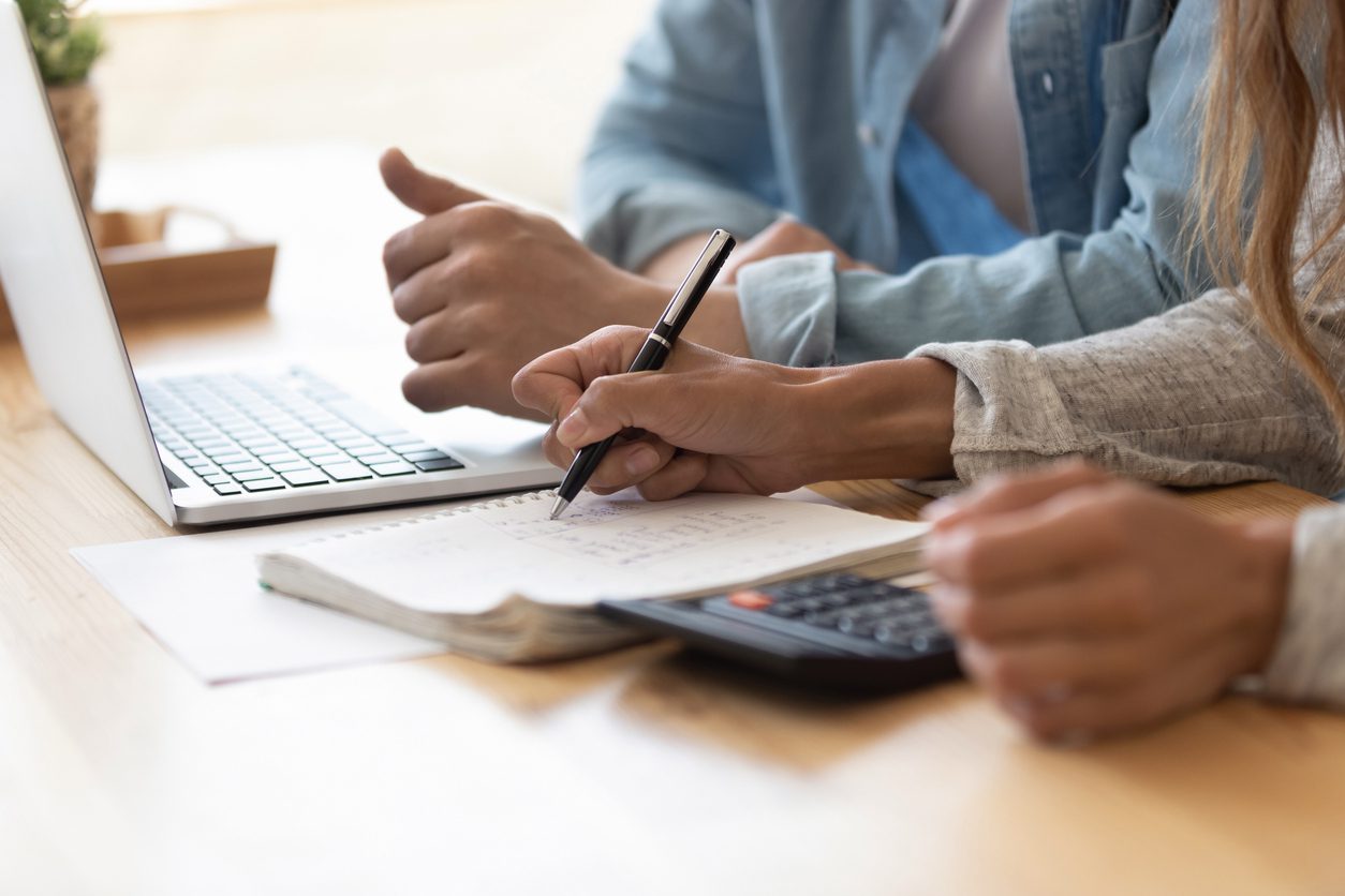 Close up spouses calculating family budget paying online using laptop