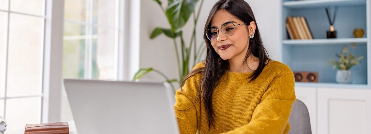 Content young woman sitting at her laptop typing