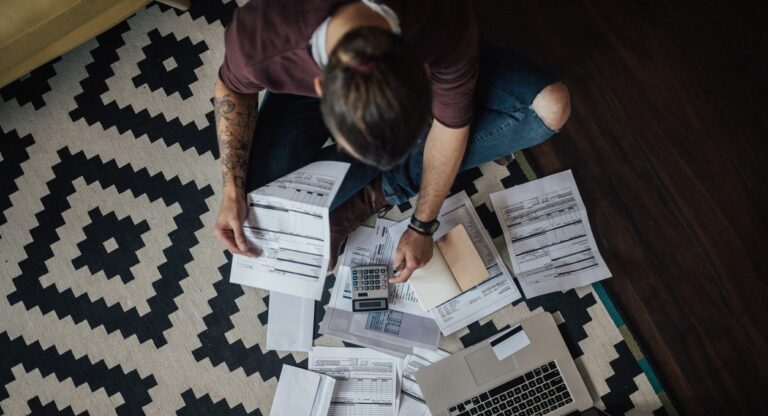 Top view of young man with bunch of overdue bills